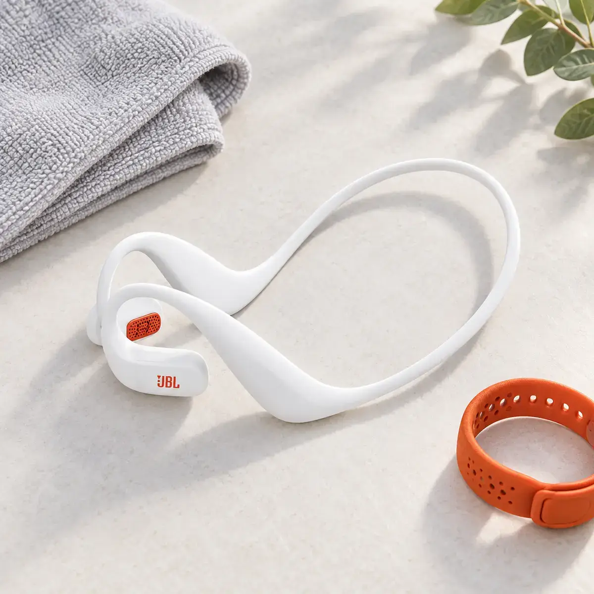 JBL Endurance Pace – תמונת ספורט אוזניות פתוחות JBL Endurance Pace לצד ציוד אימון